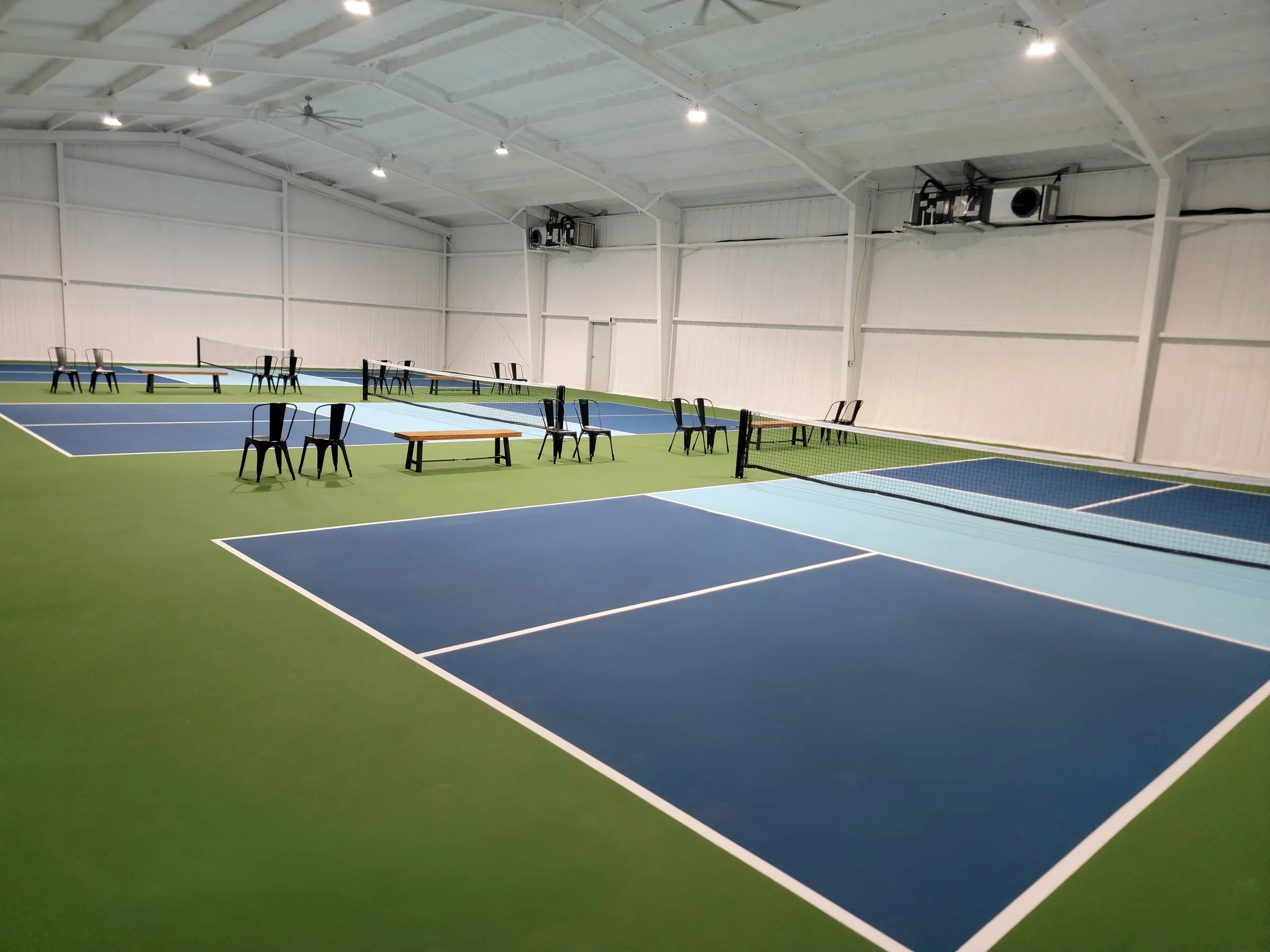 Pickle Pit Stop's three indoor courts under a high white roof